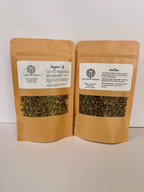 Two kraft paper pouches with herbal tea blends displayed side by side, showing labels and visible dried herbs through transparent windows